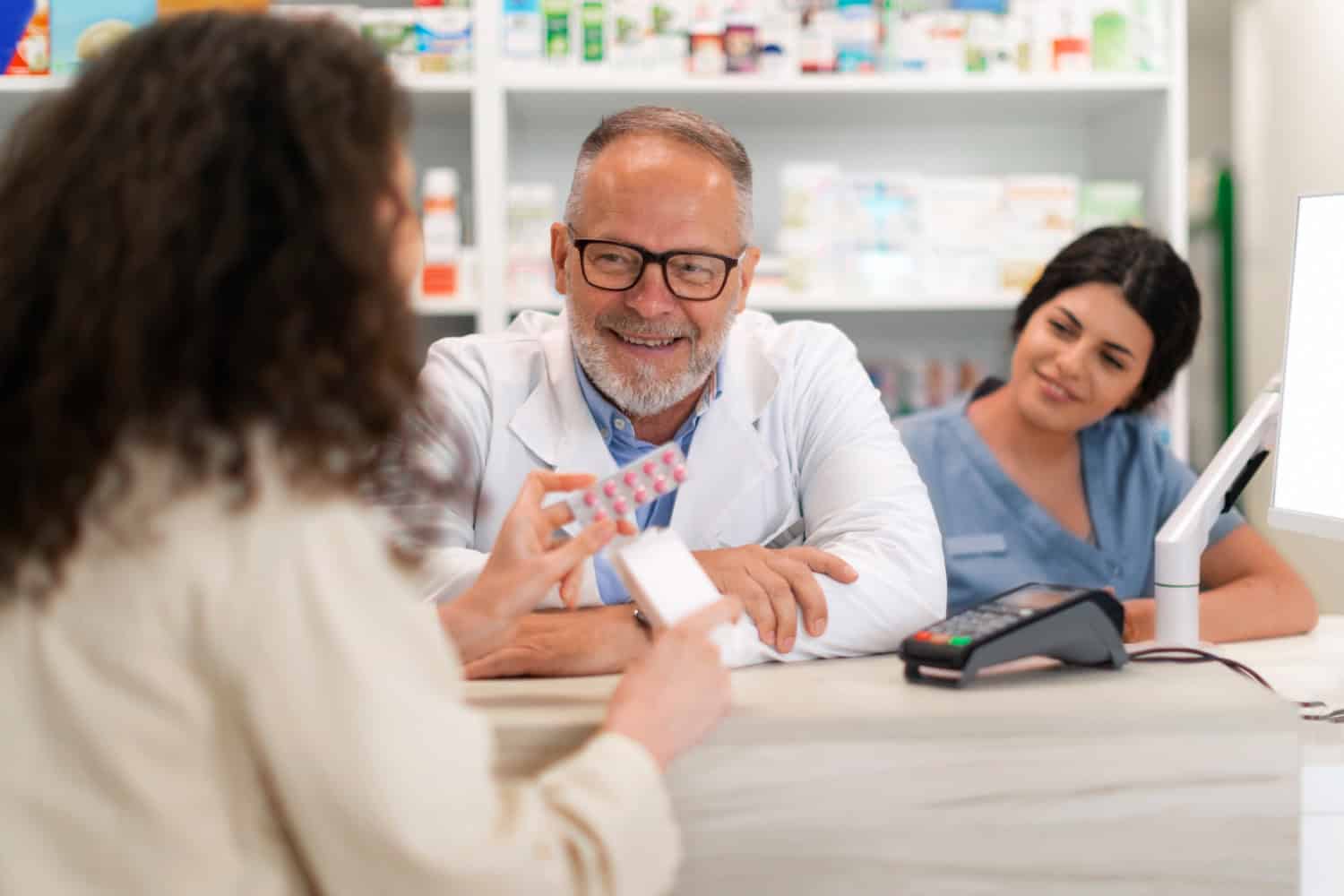 farmacista sorridente eroga pillole. Aeonvis ha supportato Pizeta Pharma nell’ottimizzazione della rete commerciale tramite l’adozione del CRM Salesforce.